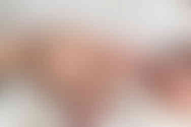 In home Sacramento lifestyle newborn photography session featuring parents and newborn baby in a light, neutral home environment with natural window light and relaxed family interaction.