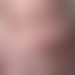 Close-up macro of newborn baby girl's face wrapped in a light pink knitted outfit and bonnet, sleeping peacefully with eyes closed. Taken by Sacramento maternity and newborn photographer Kristina Martin