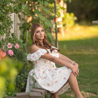 Senior portrait session at a flower farm in Sheridan, California with seasonal flowers, a greenhouse, arches, and warm sunset light.