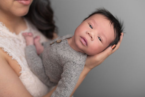 Newborn baby boy captured during a cozy in-home session by Sacramento newborn photographer, showcasing precious moments with family and adorable details.