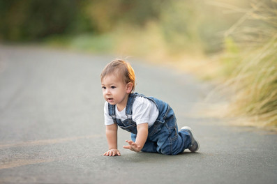 A one-year-old boy celebrating his first birthday with his parents at the Davis Arboretum in Davis, California, finishing the milestone session with a fun cake smash.