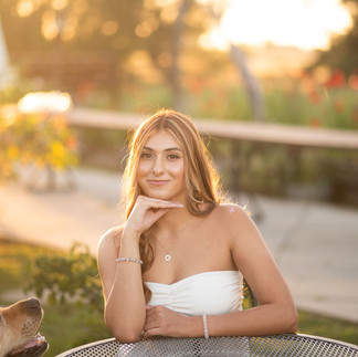 Senior portrait session at a flower farm in Sheridan, California with seasonal flowers, a greenhouse, arches, and warm sunset light.