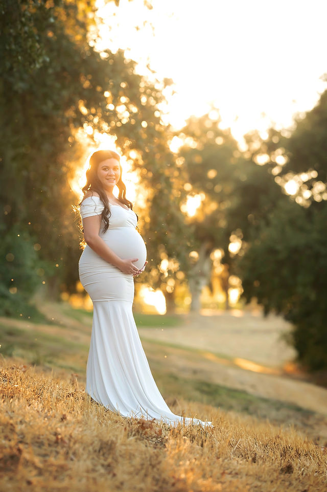 Beautiful summer maternity photoshoot at Gibson Ranch with Valentina, showcasing a glowing mom-to-be in two elegant gowns from the client closet, surrounded by warm sunset light, captured by Sacramento's best photographer, Kristina Martin.