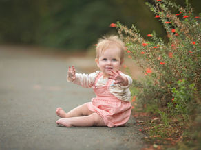 Family with a one year old baby during a milestone photography session at the UC Davis Arboretum in Davis, California.