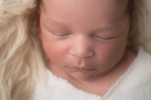 A gallery of newborn session images featuring a swaddled baby in simple, cozy setups. The photos capture a variety of angles, showing the baby peacefully resting in natural, comfortable poses. Some images are taken on a soft white backdrop, while others include a blue background or warm, textured blankets taken by Sacramento Maternity and Newborn photographer Kristina Martin Photography.