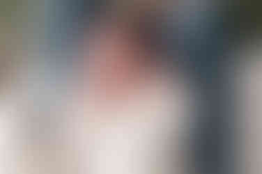 In home Sacramento lifestyle newborn photography session featuring parents and newborn baby in a light, neutral home environment with natural window light and relaxed family interaction.