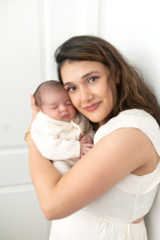 In home Sacramento lifestyle newborn photography session featuring parents and newborn baby in a light, neutral home environment with natural window light and relaxed family interaction.