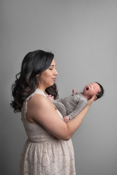 Newborn baby boy captured during a cozy in-home session by Sacramento newborn photographer, showcasing precious moments with family and adorable details.