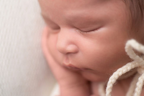 A gallery of newborn session images featuring a swaddled baby in simple, cozy setups. The photos capture a variety of angles, showing the baby peacefully resting in natural, comfortable poses. Some images are taken on a soft white backdrop, while others include a blue background or warm, textured blankets taken by Sacramento Maternity and Newborn photographer Kristina Martin Photography.