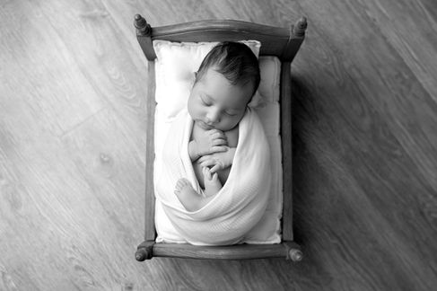 Sweet newborn baby boy peacefully sleeping in a cozy studio setting, wrapped in soft neutrals of cream and white, with delicate details captured like tiny toes, hands, and lashes. Family photos included tender moments with mom and dad. Taken by the best maternity and newborn photographer in Sacramento, Kristina Martin Photography.