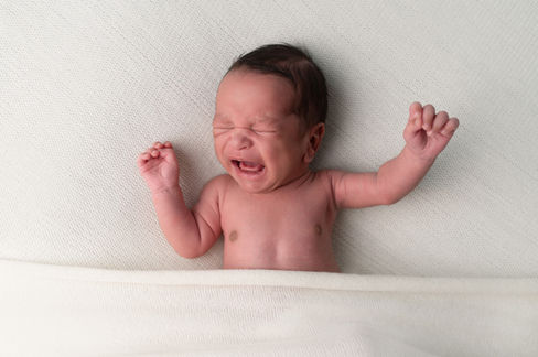 A gallery of newborn session images featuring a swaddled baby in simple, cozy setups. The photos capture a variety of angles, showing the baby peacefully resting in natural, comfortable poses. Some images are taken on a soft white backdrop, while others include a blue background or warm, textured blankets taken by Sacramento Maternity and Newborn photographer Kristina Martin Photography.