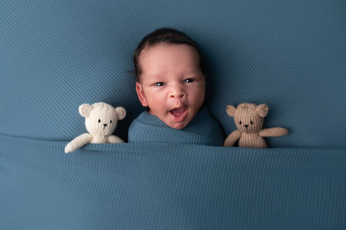A gallery of newborn session images featuring a swaddled baby in simple, cozy setups. The photos capture a variety of angles, showing the baby peacefully resting in natural, comfortable poses. Some images are taken on a soft white backdrop, while others include a blue background or warm, textured blankets taken by Sacramento Maternity and Newborn photographer Kristina Martin Photography.