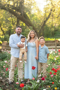 Sacramento family photographer capturing a spring botanical garden first birthday and cake smash session with blooming tulips, teddy bear decor, and natural family portraits.