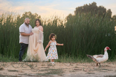 Beautiful maternity session at a Sacramento Ranch in California. Captured by the finest maternity photographer. A mother, her husband, and their shy but sweet daughter during golden California sunset.
