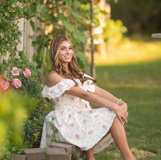 Senior portrait session at a flower farm in Sheridan, California with seasonal flowers, a greenhouse, arches, and warm sunset light.