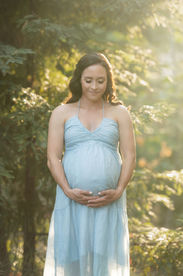 A glowing maternity session at the Davis Arboretum near Sacramento, captured by Kristina Martin Photography. The expecting couple stands in natural, serene surroundings, illuminated by soft golden light, celebrating their upcoming arrival.