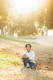 Senior portrait of Ali outdoors in Sacramento with personal items that reflect his interests and personality.