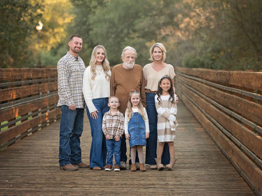 Extended family posing together on a wooden bridge at a Citrus Heights nature reserve during a fall family photography session.