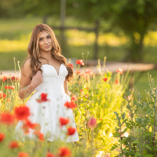 Senior portrait session at a flower farm in Sheridan, California with seasonal flowers, a greenhouse, arches, and warm sunset light.
