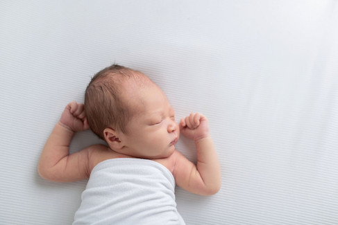 Newborn baby Owen peacefully posed during a simple, classic Sacramento and Roseville studio newborn photography session with soft neutral tones and gentle wrapping.