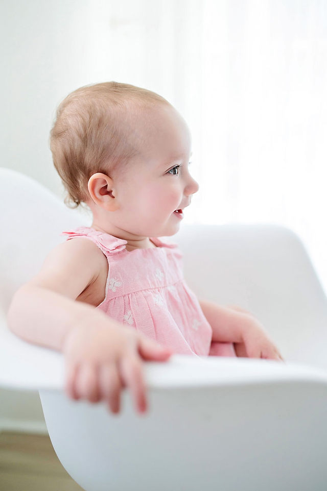 Roseville studio one year milestone session featuring a baby girl, simple white cake smash setup, natural sibling moments, and soft backlit family photography by a Sacramento photographer.