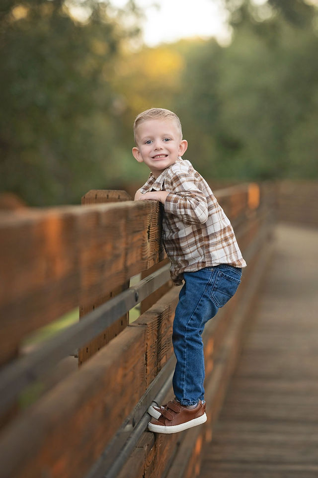 Extended family posing together on a wooden bridge at a Citrus Heights nature reserve during a fall family photography session.