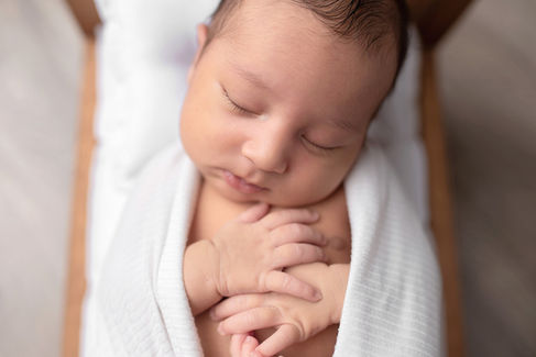 Sweet newborn baby boy peacefully sleeping in a cozy studio setting, wrapped in soft neutrals of cream and white, with delicate details captured like tiny toes, hands, and lashes. Family photos included tender moments with mom and dad. Taken by the best maternity and newborn photographer in Sacramento, Kristina Martin Photography.