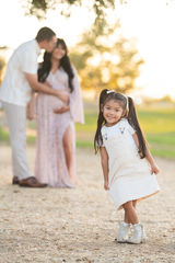 Little girl smiling brightly at the camera, embracing the excitement of becoming a big sister, photographed by the best Sacramento maternity photographer.