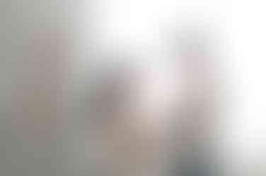 In home Sacramento lifestyle newborn photography session featuring parents and newborn baby in a light, neutral home environment with natural window light and relaxed family interaction.