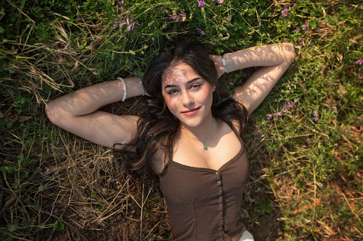 Sacramento senior photographer capturing a golden hour iris farm senior session with blooming flowers, artistic natural light, cap and gown portraits, and personality-filled senior photography.