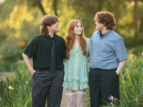 Sacramento family photographer capturing a spring iris farm family session with golden hour light, tall grass, soft garden blooms, and natural family portraits.