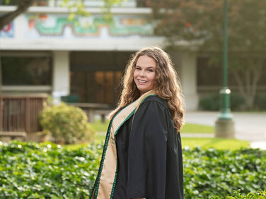 Sacramento senior photographer capturing a Sacramento State graduation session with natural light portraits, blooming roses, green campus walkways, and cap and gown images.