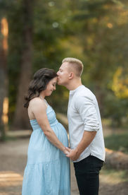 A glowing maternity session at the Davis Arboretum near Sacramento, captured by Kristina Martin Photography. The expecting couple stands in natural, serene surroundings, illuminated by soft golden light, celebrating their upcoming arrival.