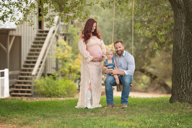 Expecting family with a young child during a golden hour maternity photography session at the Lavender Farm in Lincoln, California.