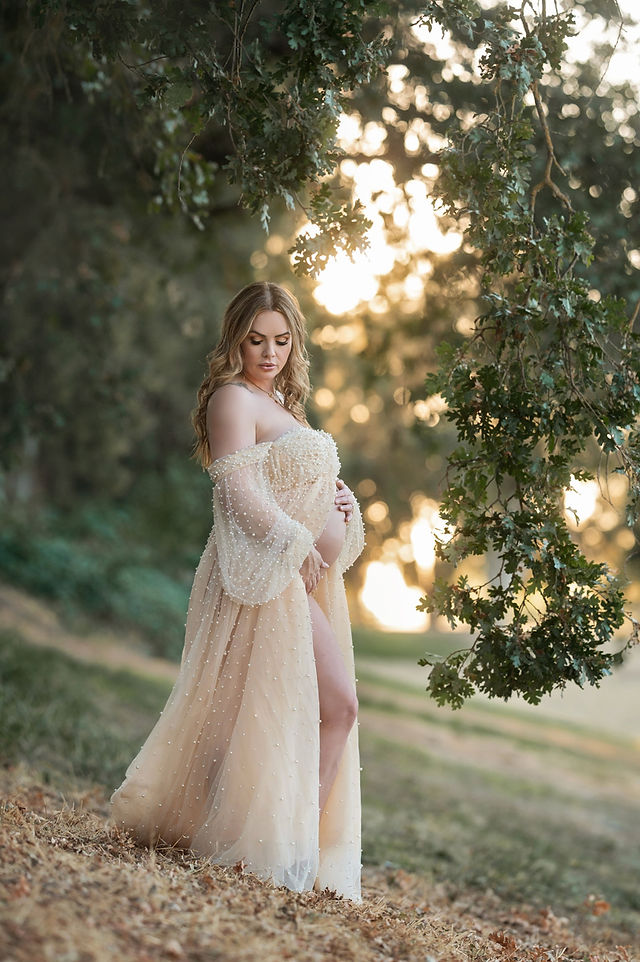 Beautiful outdoor maternity session captured in soft, golden summer light. Expecting mother poses gracefully in a neutral-toned, flowing maternity gown with nature as the backdrop. Taken by the best Sacramento maternity photographer, Kristina Martin Photography.