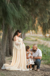 Beautiful maternity session at a Sacramento Ranch in California. Captured by the finest maternity photographer. A mother, her husband, and their shy but sweet daughter during golden California sunset.