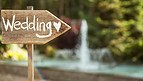Holzwegweiser 'Wedding' mit Herz vor Brunnen