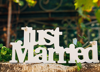 "Just Married"-Schild auf Stein mit Grünpflanzen
