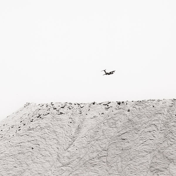 a fireplane flying over a hill of salt during a fire