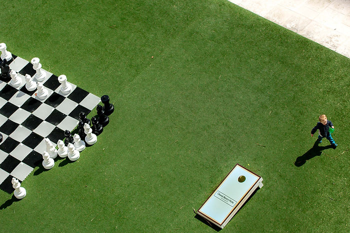 a kid playing close to a chessboard