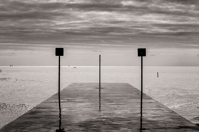 a small pier overflowed by the sea