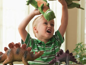 Toddler playing out dinosaurs