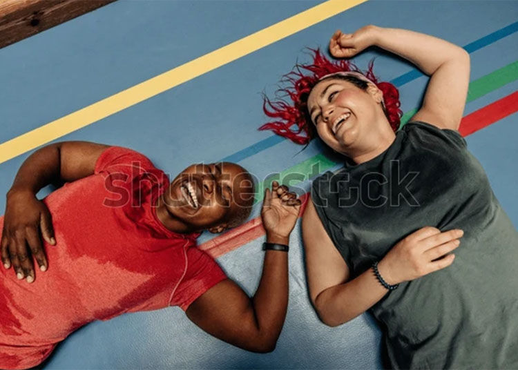 a shutterstock image of two women laughing after doing exercise