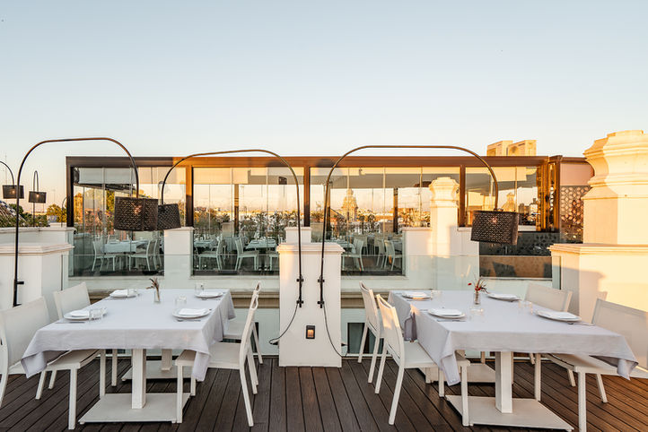 Terraza restaurante Sevilla: mesas blancas, vistas atardecer