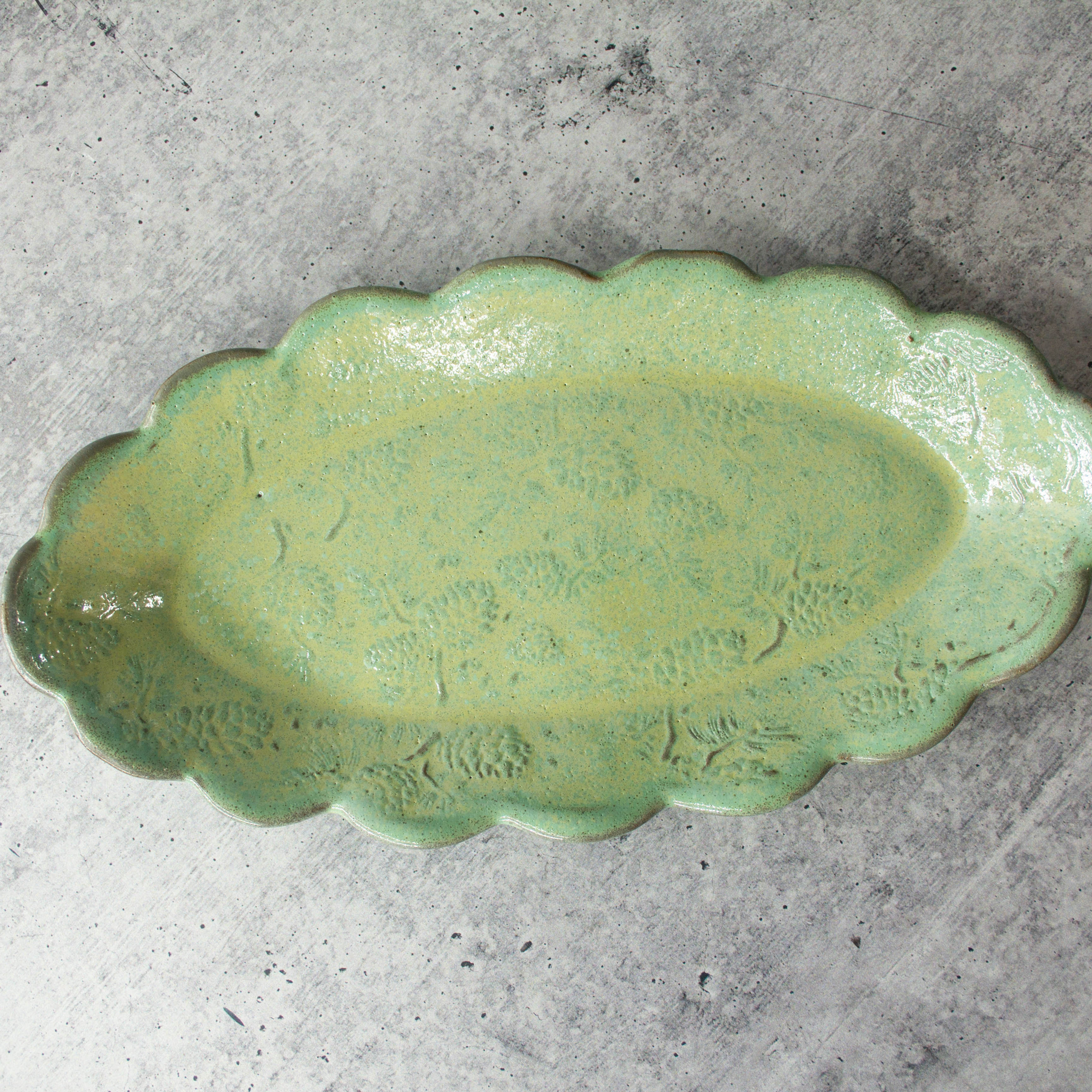 Handmade ceramic relish dish with scalloped edges and pine cone texture, hand-built from stoneware with detailed impressions