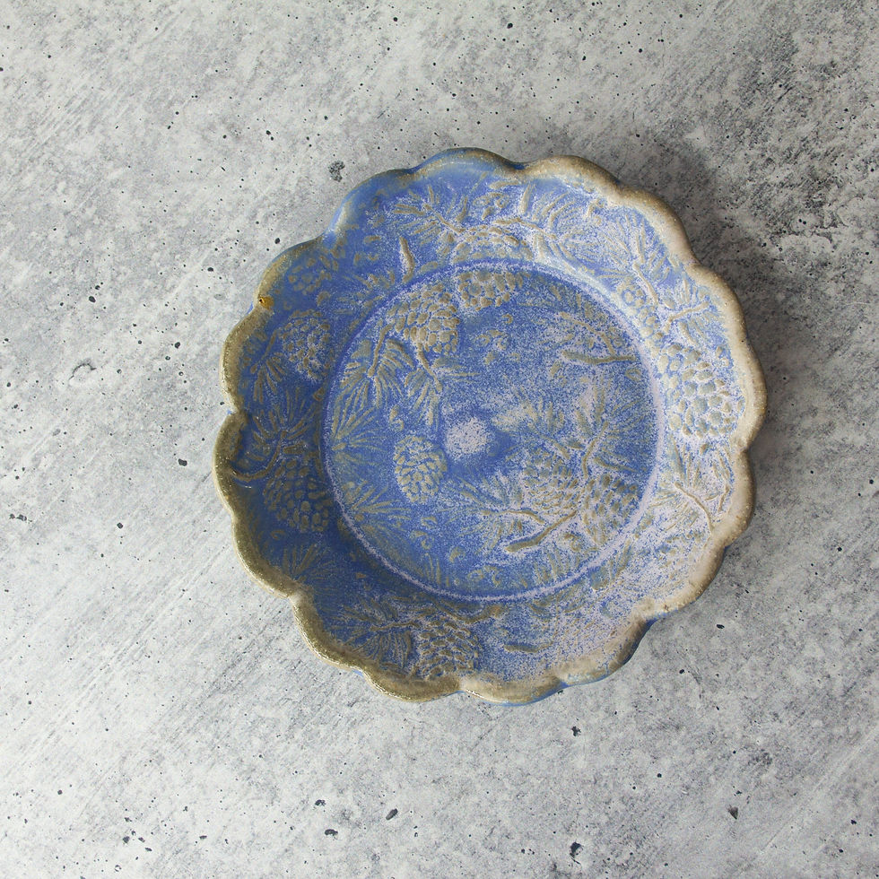 handmade ceramic tapas dish with scalloped edge and detailed pine cone texture, rustic glaze finish.