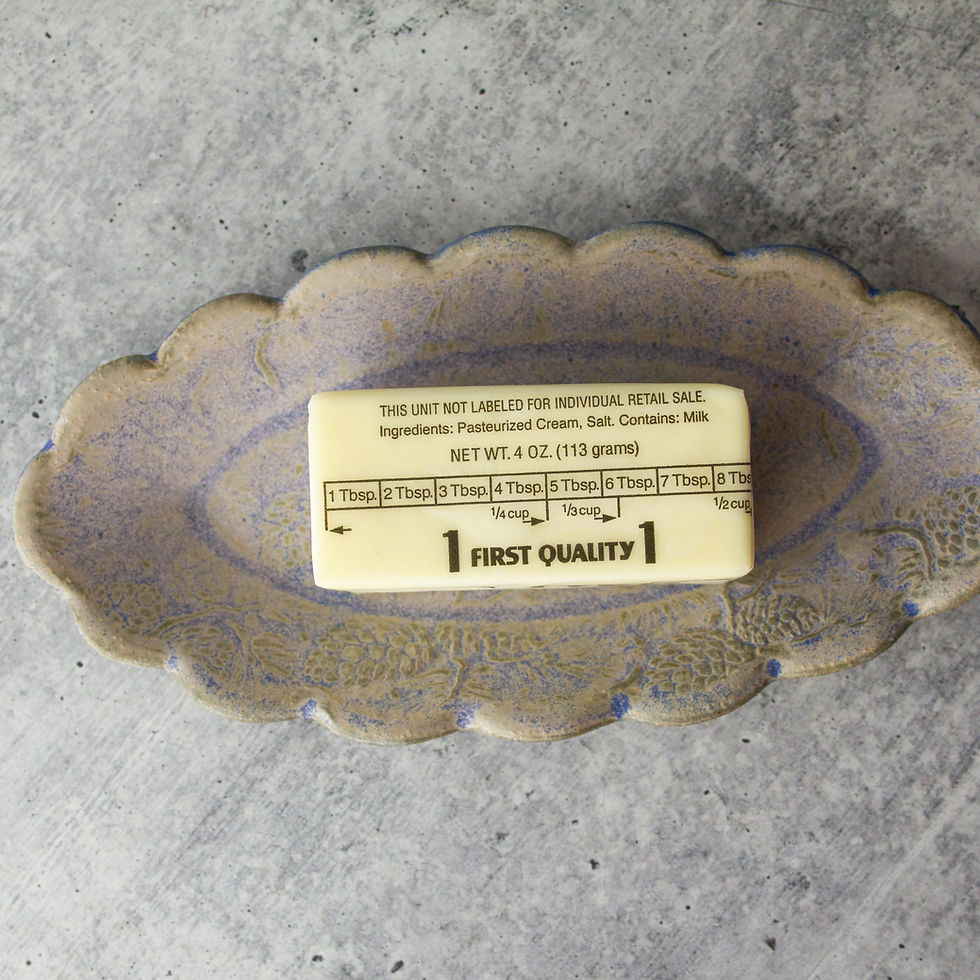 Thumbnail: handmade oval ceramic butter dish with scalloped edge and embossed pine cone pattern.