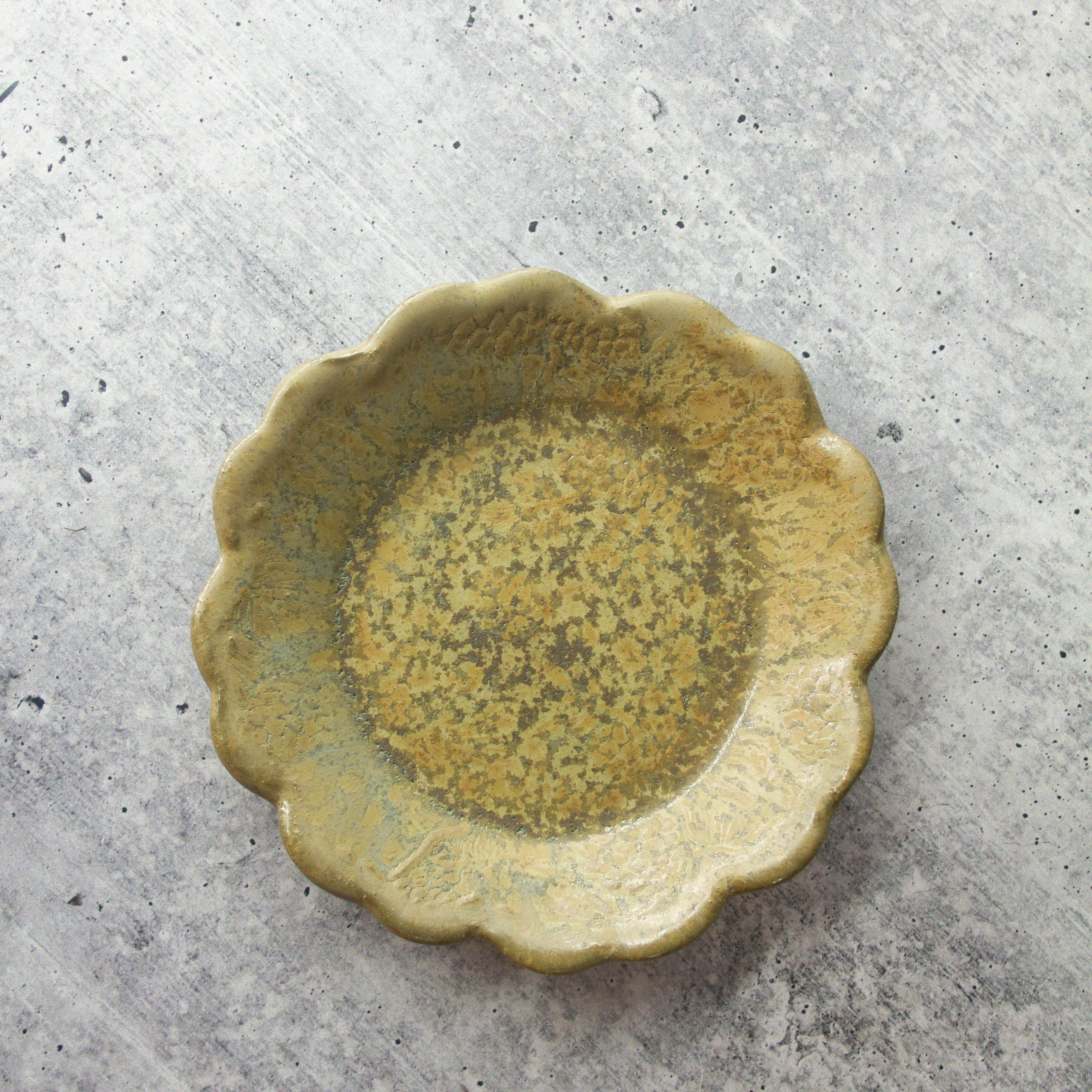 handmade ceramic tapas dish with scalloped edge and detailed pine cone texture, rustic glaze finish.