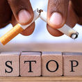 Deux mains déchirent une cigarette au dessus du mot STOP