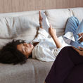 Femme allongée sur le canapé qui tient une feuille